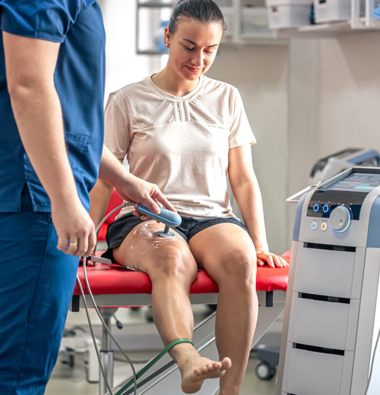 Doctor using machine to treat the knee joints of a patient, T-CaRe technology, resistive and Capacitive therapy.